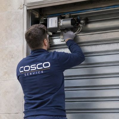 Un fabbro di Cosco che ripara una serranda rendelola motorizzata
